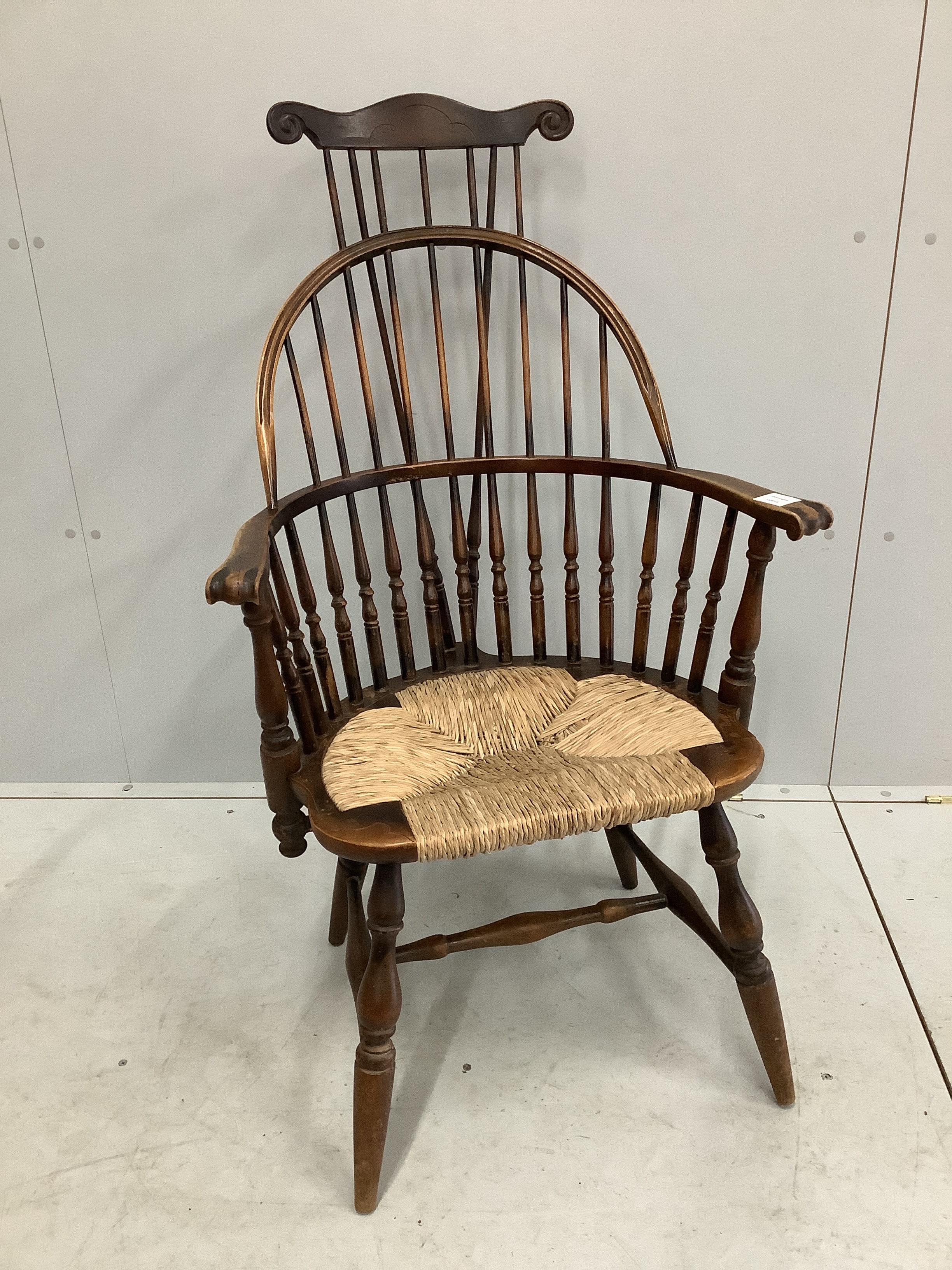 A reproduction American style beech rush seat Windsor comb back armchair, width 64cm, depth 50cm, height 114cm